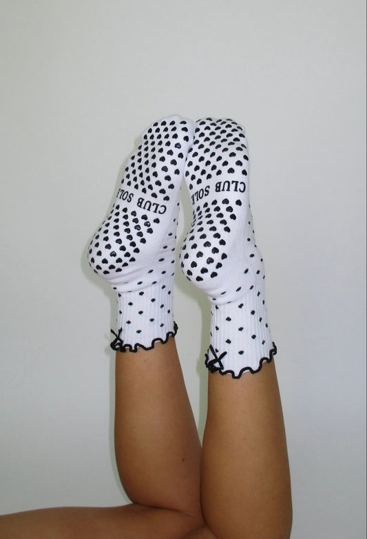 White socks with black polka dots and text on a plain background